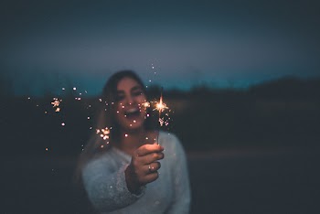 Smiling Woman Holding Sparkler during Nighttime
