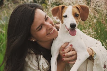 Smiling Woman Holds White Short Coat Small Dog