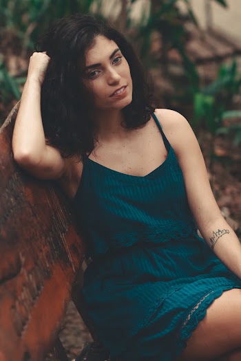 Smiling Woman in Green Tank Dress on Park Bench