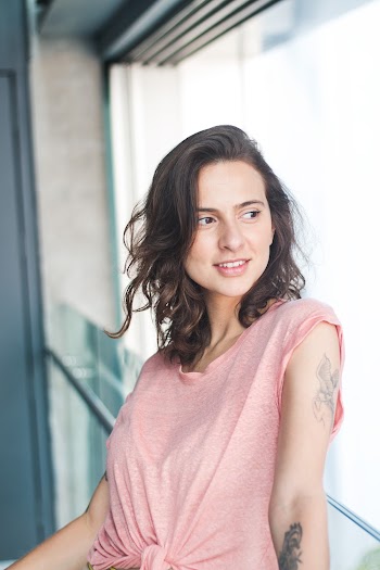 Smiling Woman Leaning on Glass Wall