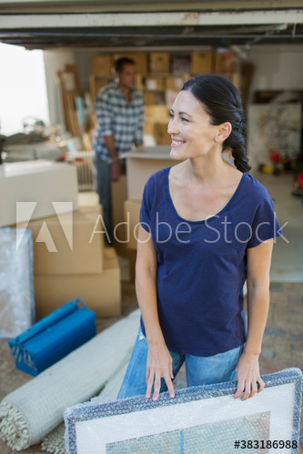 Smiling woman moving belongings into garage