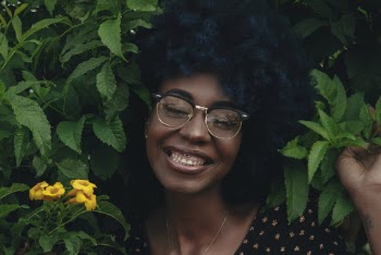 Smiling Woman Posing Near Green Plants