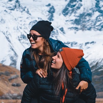 Smiling Woman Riding Woman's Back during Day