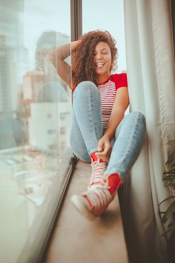 Smiling Woman Sitting Beside Glass Panel
