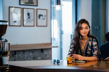 Smiling Woman Sitting in Front of Table
