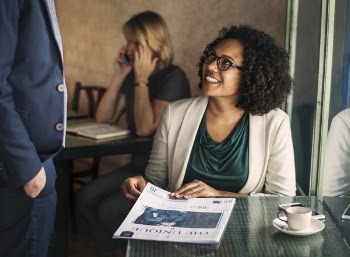 Smiling Woman Sitting on Chair Beside Table and Window
