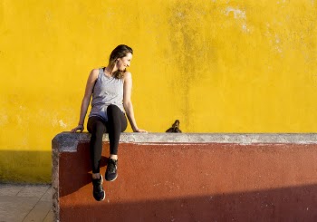 Smiling Woman Sitting on Orange Barrier