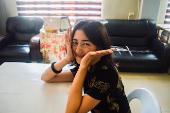 Smiling Woman Sitting on White Chair Beside Table