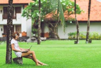 Smiling Woman Sitting While Using Laptop