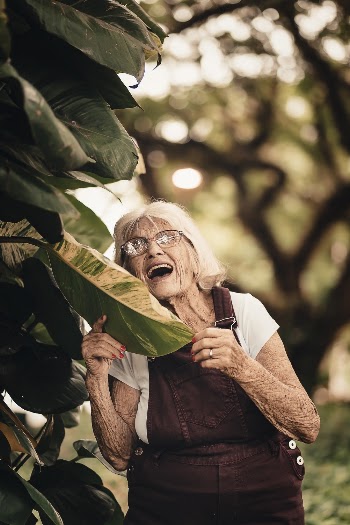Smiling Woman Standing Beside Green-leafed Plant