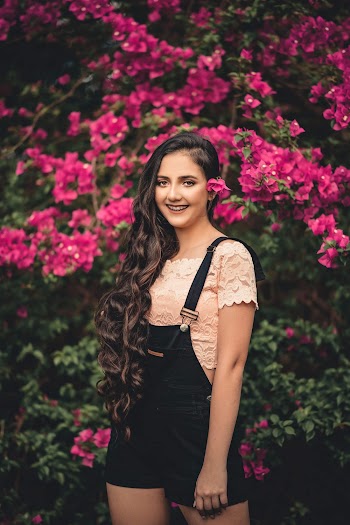 Smiling Woman Standing Beside Pink Flowers