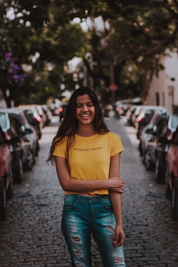 Smiling Woman Standing Between Vehicles