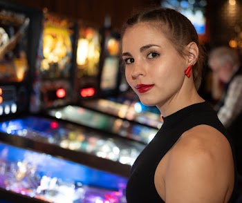 Smiling Woman Standing Near Arcade Machine