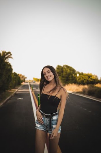 smiling woman standing under gray sky