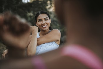 Smiling Woman Stretching in Front of Woman