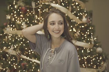 Smiling Woman Touching Her Hair Near Christmas Tree