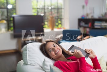 Smiling woman using digital tablet on sofa