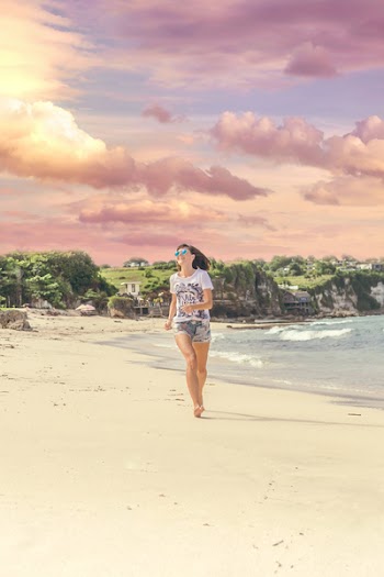 Smiling Woman Walking Barefood on Seashore Near Houses