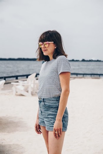 Smiling Woman Wearing Black and White Striped Shirt and Blue Short Shorts