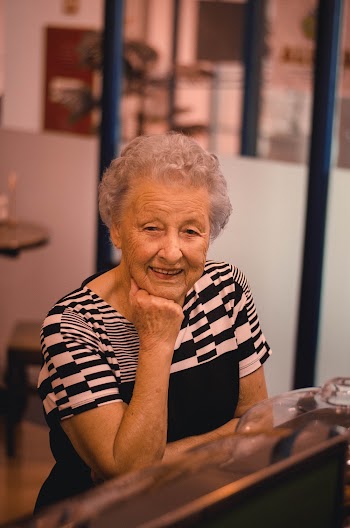 Smiling Woman Wearing Black and White Top Resting Head on Right Hand