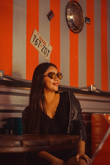 Smiling Woman Wearing Black Leather Jacket and Brown Sunglasses