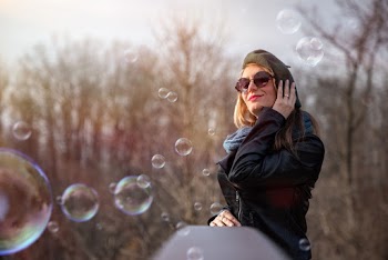 Smiling Woman Wearing Black Zip-up Jacket Holding Beret Cap