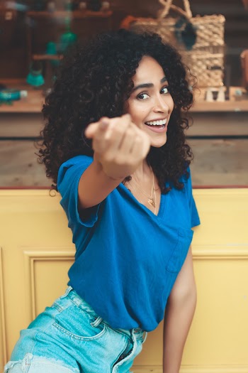 Smiling Woman Wearing Blue Top and Blue Denim Bottoms