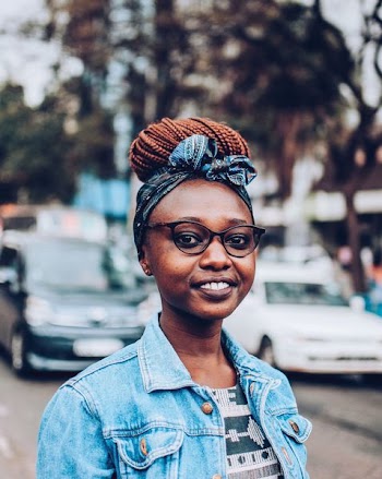 Smiling Woman Wearing Eyeglasses Standing on Street Near Parked Cars during Day