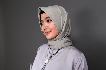 Smiling Woman Wearing Gray Hijab Beside Gray Wall
