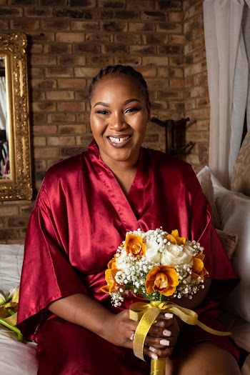 Smiling Woman Wearing Red Robe Holding White And Yellow Bouquet