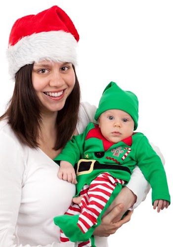 Smiling Woman Wearing Santa Hat Carring Baby Wearing Elf Costume