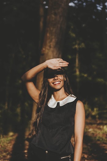 Smiling Woman Wearing White and Black Sleeveless Shirt Near the Tree Outdoor