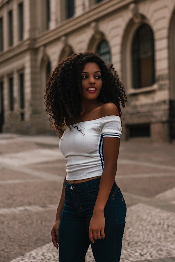 Smiling Woman Wearing White Off-shoulder Shirt Standing Near Building