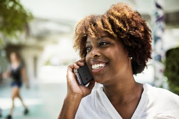 Smiling Woman Wearing White V-neck Shirt Holding Grey Smartphone