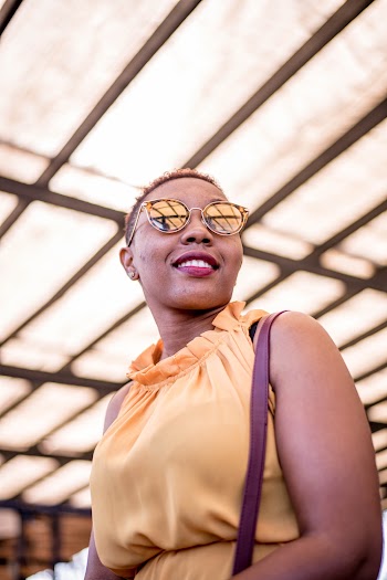 Smiling Woman Wearing Yellow Sleeveless Top and Sunglasses