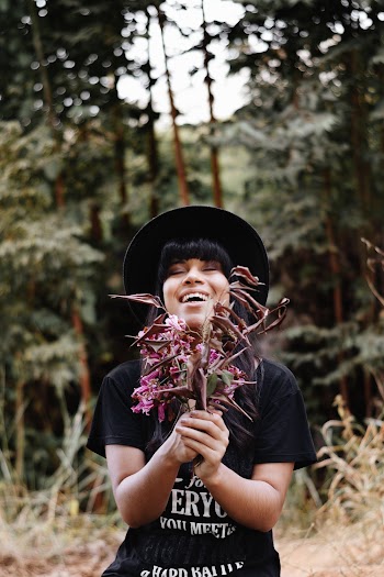 Smiling Woman With Bunch of Pink Roses Standing in Woods