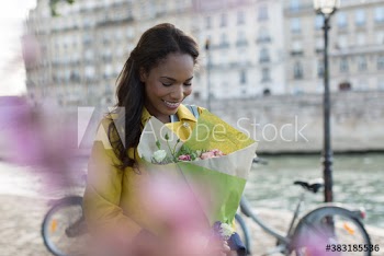 Smiling woman with flower bouquet at Seine River, Paris, France