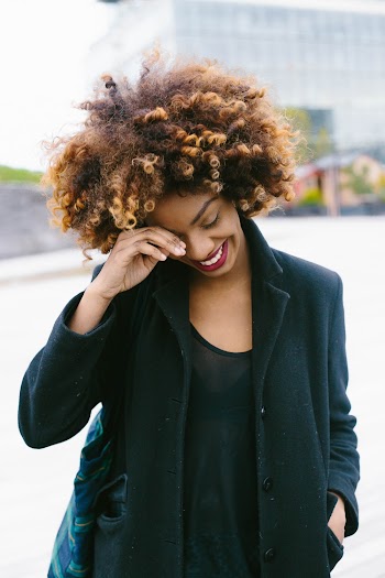 Smiling Woman With Right Hand on Forehead