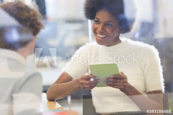 Smiling young businesswoman with digital tablet in meeting