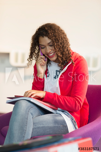 Smiling young female college student talking on smart phone