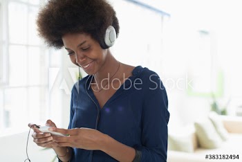 Smiling young woman listening to music with headphones and mp3 player