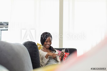 Smiling young woman listening to music with headphones and smart phone