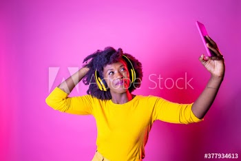 Smiling young woman taking selfie indoors