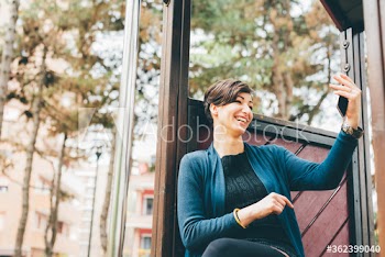 Smiling young woman taking selfie outdoors