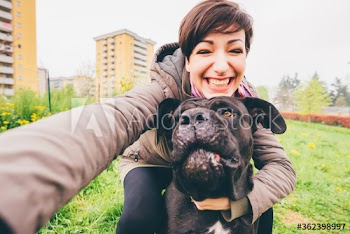 Smiling young woman taking selfie with her dog