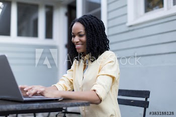 Smiling young woman using laptop on patio