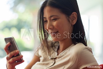 Smiling young woman using smart phone