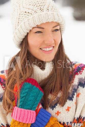 Smiling young woman wearing knit hat and mittens