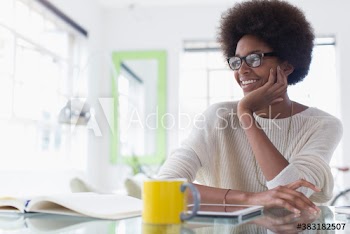 Smiling young woman with afro working from home