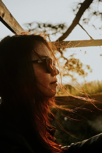 Smirking Woman While Wearing Black Sunglasses during Golden Hour